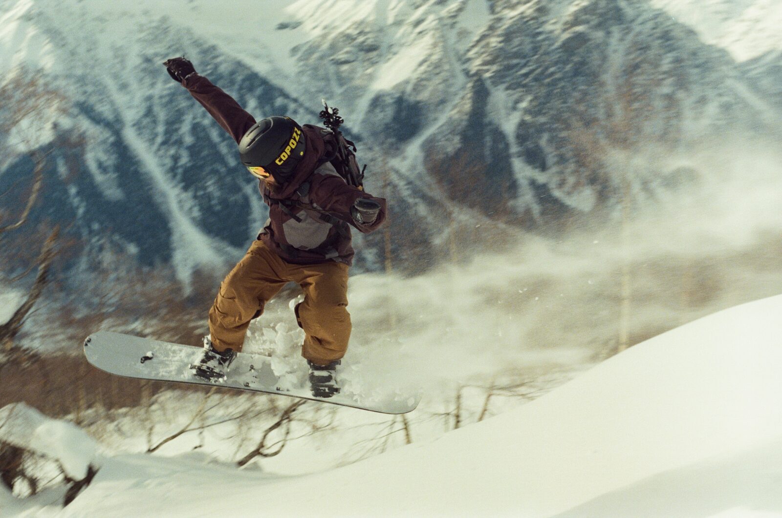 Snowboarder mid-air off a wind lip in the mountains